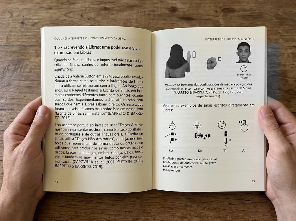 Páginas 44 e 45 abertas, com fotos reais de configuração de mão e de sobrancelhas erguidas ao lado dos grafemas da Escrita de Sinais e quatro frases escritas em Libras